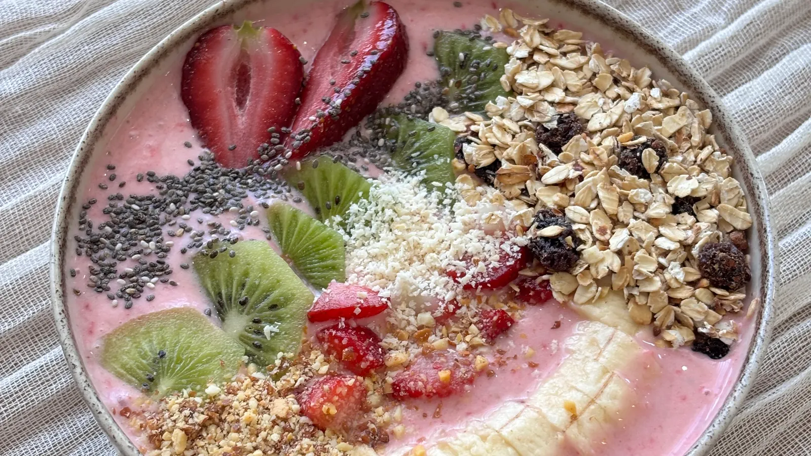 Healthy smoothie bowl topped with fresh fruit and granola