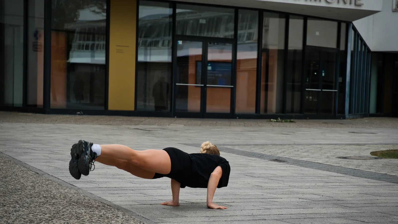Person doing a strength training pose inside the Berlin Philharmonic while traveling