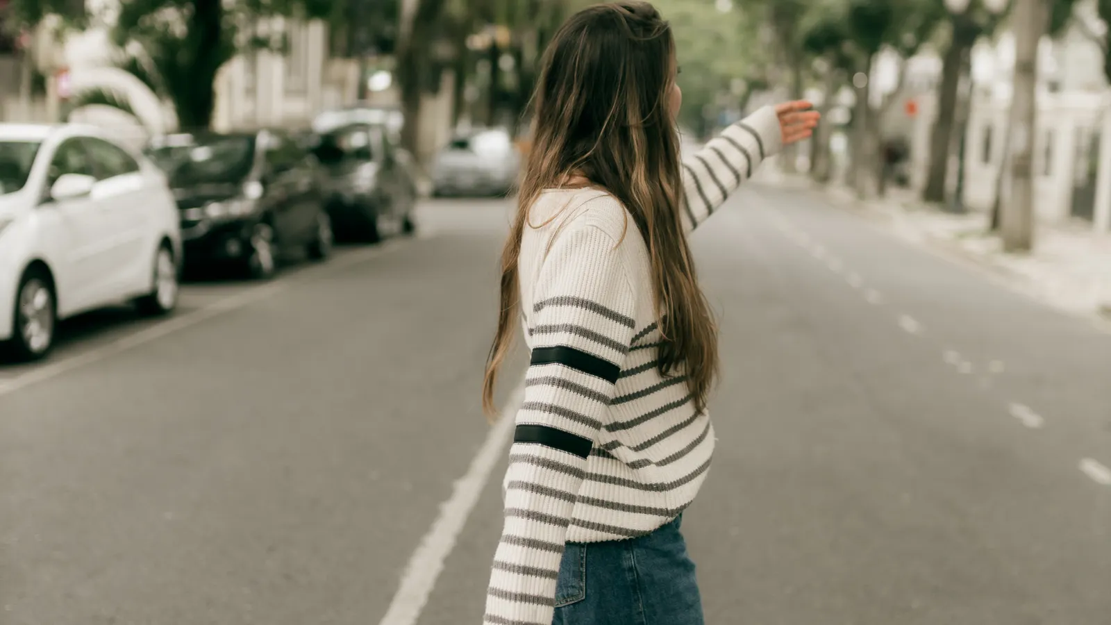 Person walking briskly along a tree-lined outdoor path