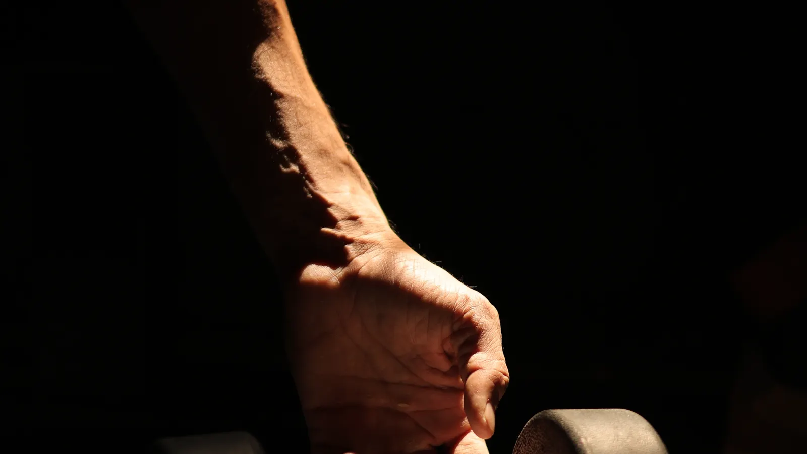 Hand gripping a dumbbell during a curl