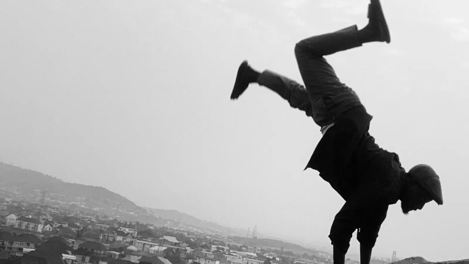 Silhouette of a person doing a handstand outdoors