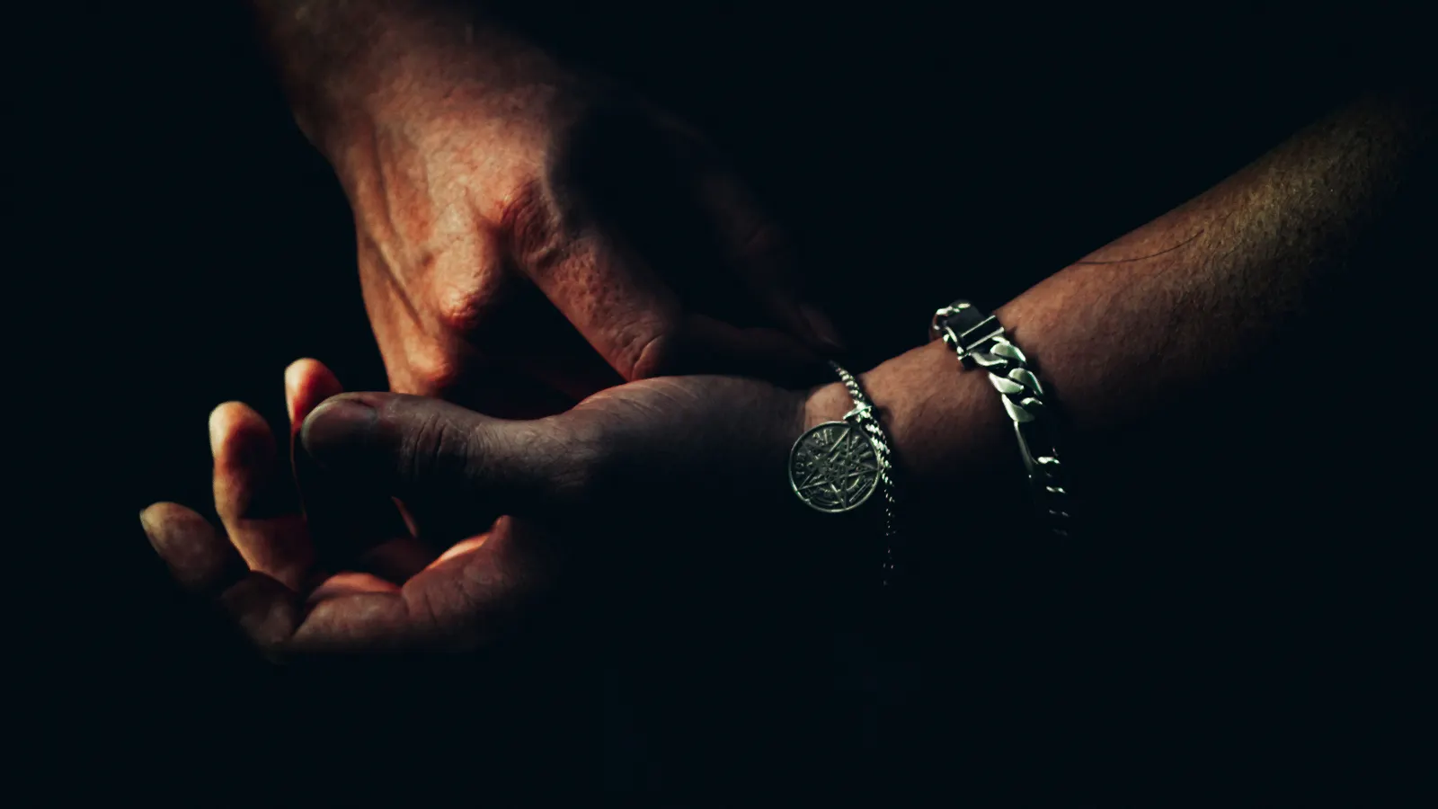 Close-up of hands gripping in dramatic lighting