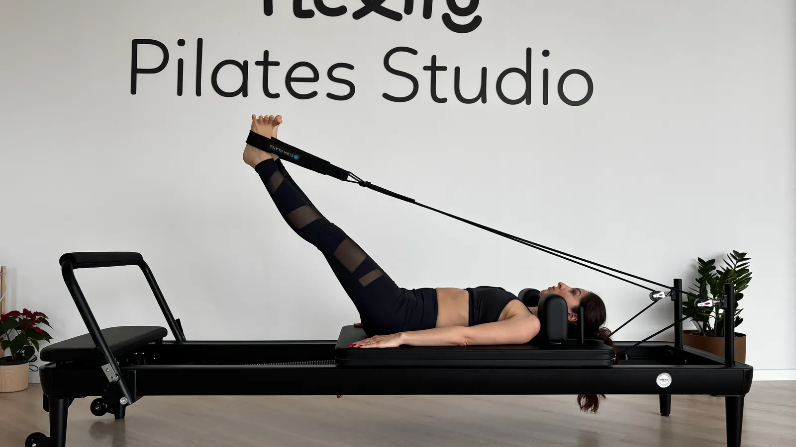 Woman training on a pilates reformer in a studio