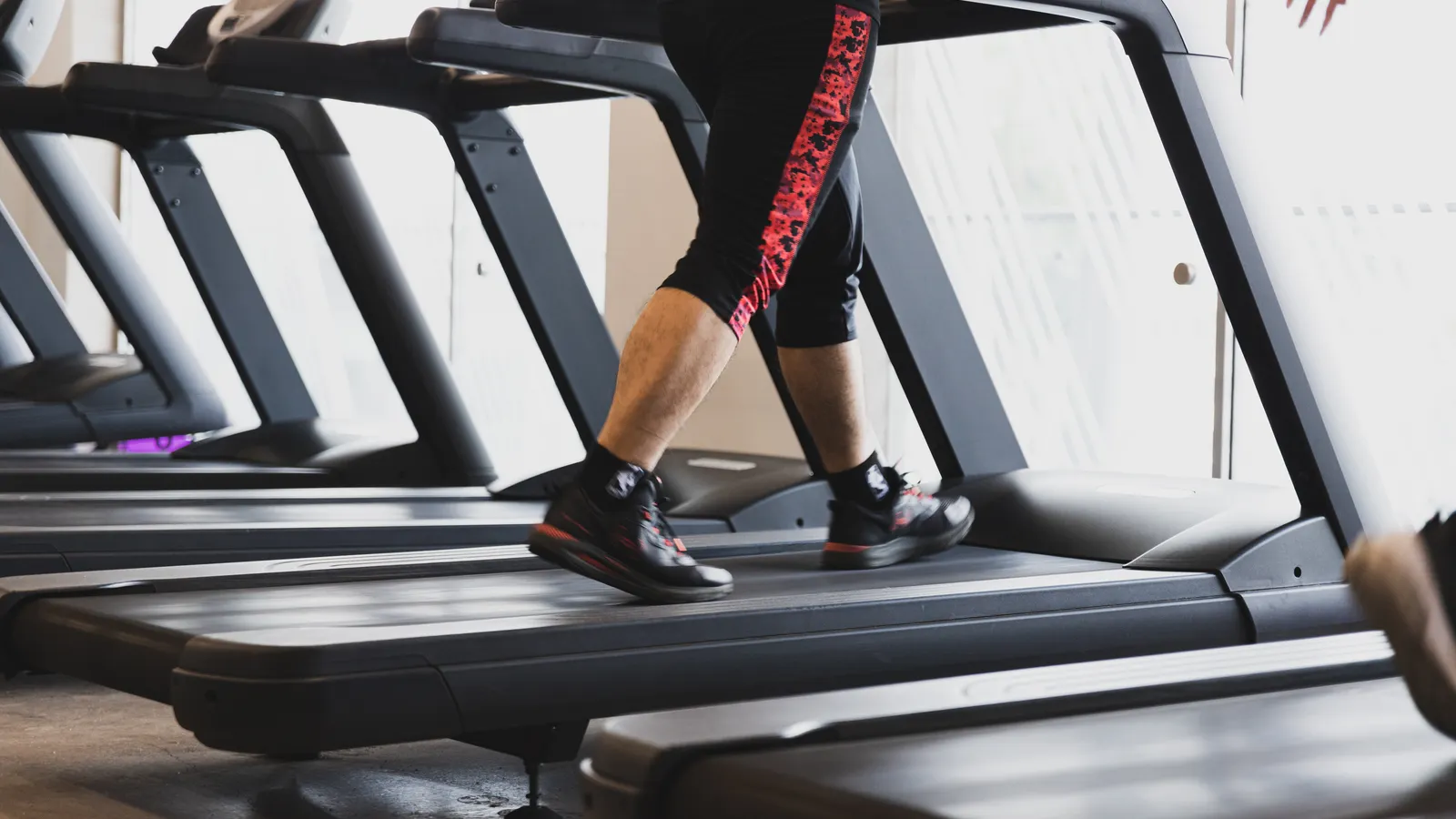 Active person walking on a treadmill in the gym